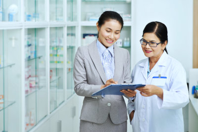 Asian business women showing document to pharmacy worker